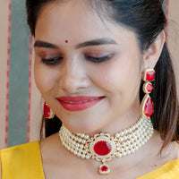 Pearl choker studded with bright ruby stones as a statement paired with ruby stone earrings
